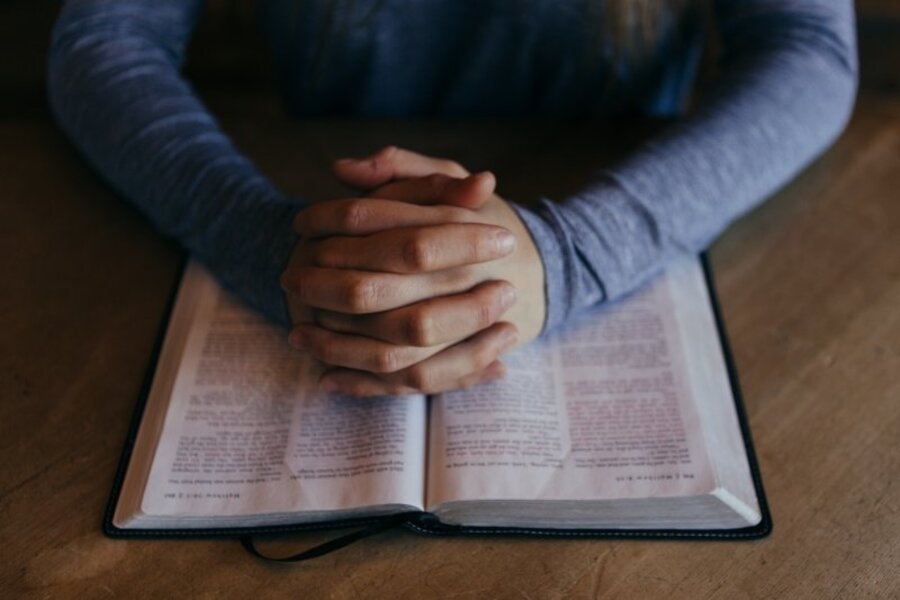 Mani in preghiera su una Bibbia aperta